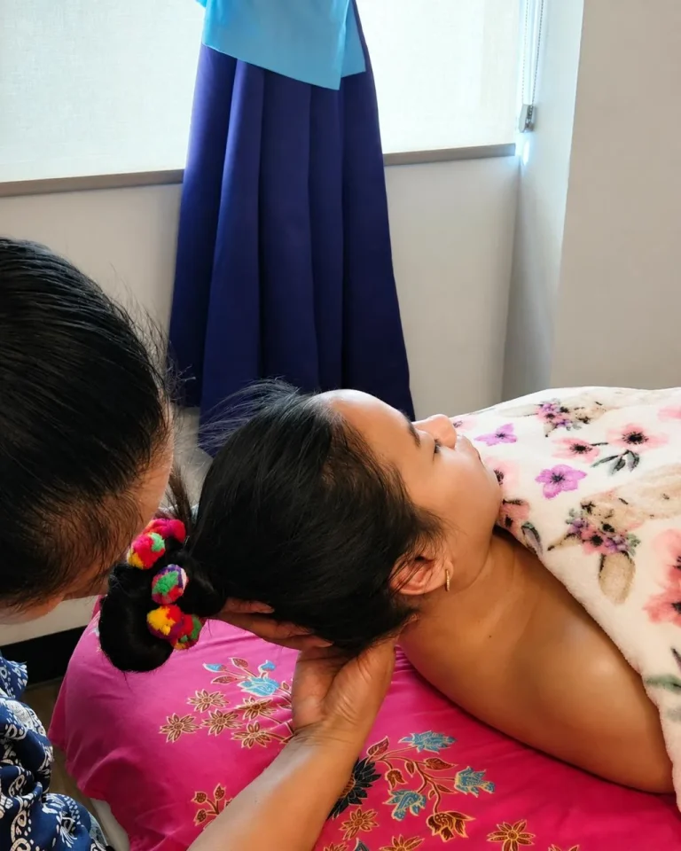 Therapist supporting a client’s head while massaging the neck at Siam Thai Yoga Massage